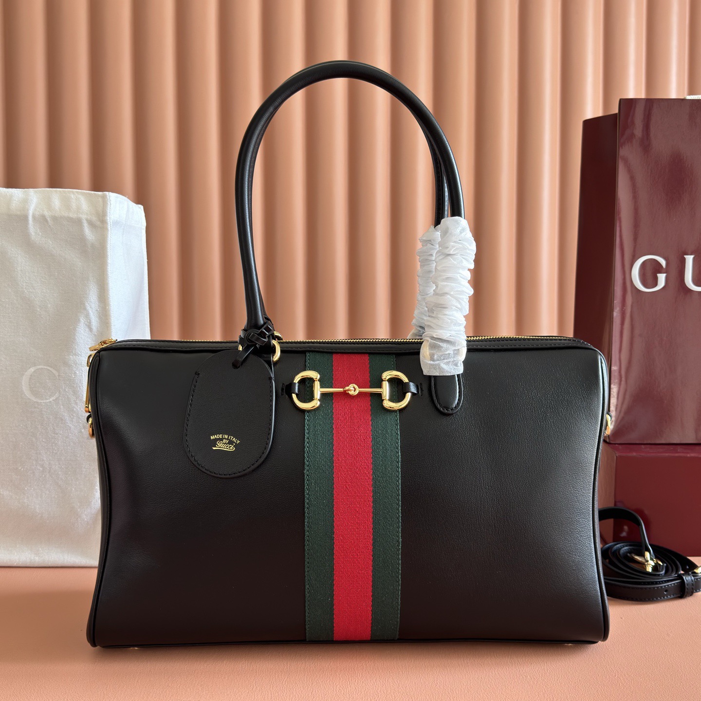 💋💋💋2026春夏系列全新上市。Gucci Borsetto系列名称巧妙融合意大利语“borsa”（手袋）和“morsetto”（马衔扣）二词。 这款手袋甄选柔软牛皮革打造，源自典藏的钻石菱格纹图案演绎全新衬里。 黑色软皮 金色调配件 黑色帆布衬里，饰钻石菱格纹图案 Horsebit、Web 和牛皮革标签，带有“Made in Italy Gucci”标志 内部：1个拉链口袋 手柄高：23厘米 可拆卸和可调节的牛皮革肩带，高：46 - 49厘米；长度：101 - 109厘米 双拉链开合 型号：866734。 尺寸：38.5厘米（宽）x 22.5厘米（高）x 13厘米（深） 重量：约0.9千克 颜色：黑色全皮。 意大利创作