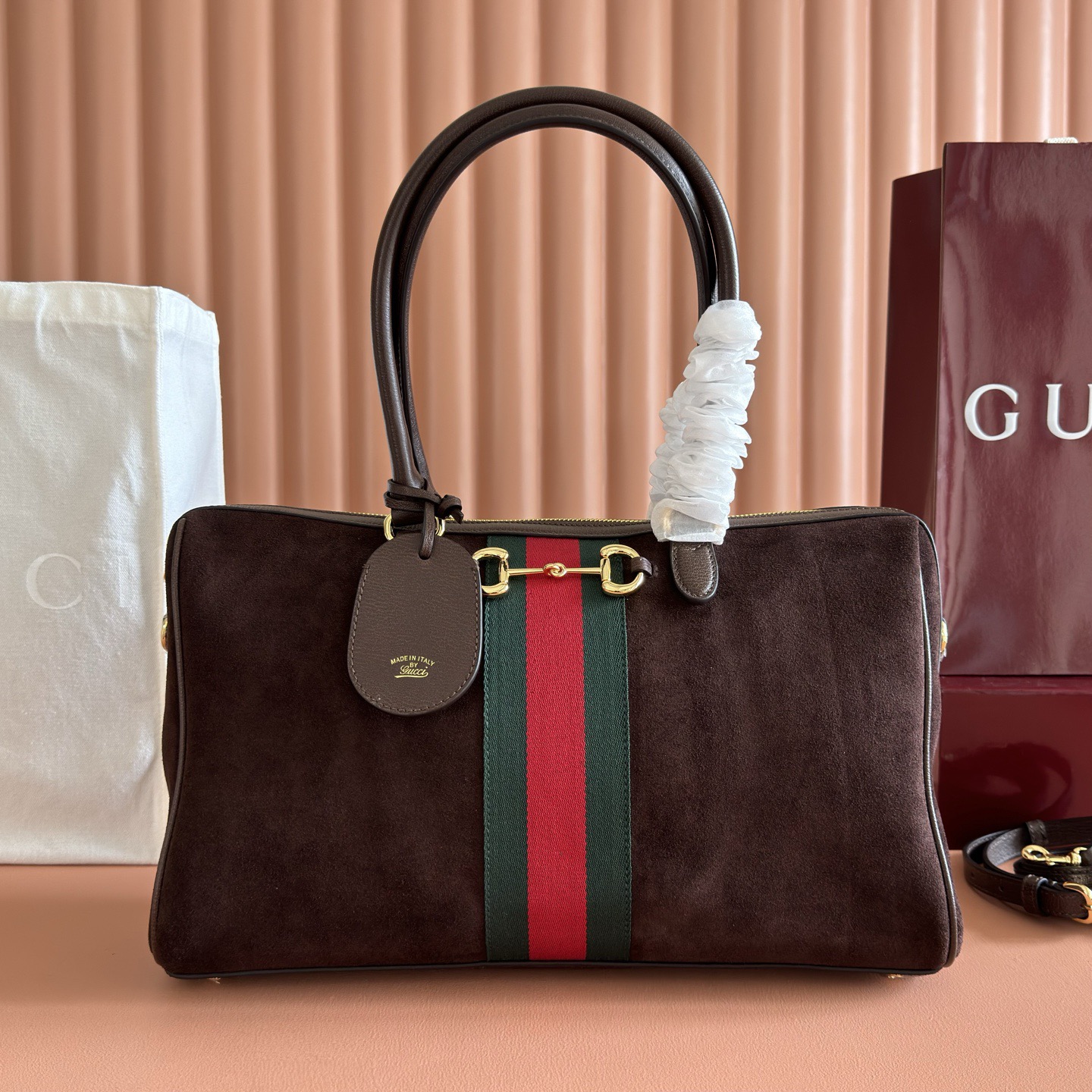 💋💋💋2026春夏系列全新上市。Gucci Borsetto系列名称巧妙融合意大利语“borsa”（手袋）和“morsetto”（马衔扣）二词。 这款手袋甄选柔软牛皮革打造，源自典藏的钻石菱格纹图案演绎全新衬里。 黑色软皮 金色调配件 黑色帆布衬里，饰钻石菱格纹图案 Horsebit、Web 和牛皮革标签，带有“Made in Italy Gucci”标志 内部：1个拉链口袋 手柄高：23厘米 可拆卸和可调节的牛皮革肩带，高：46 - 49厘米；长度：101 - 109厘米 双拉链开合 型号：866734。 尺寸：38.5厘米（宽）x 22.5厘米（高）x 13厘米（深） 重量：约0.9千克 颜色：棕磨砂全皮。 意大利创作