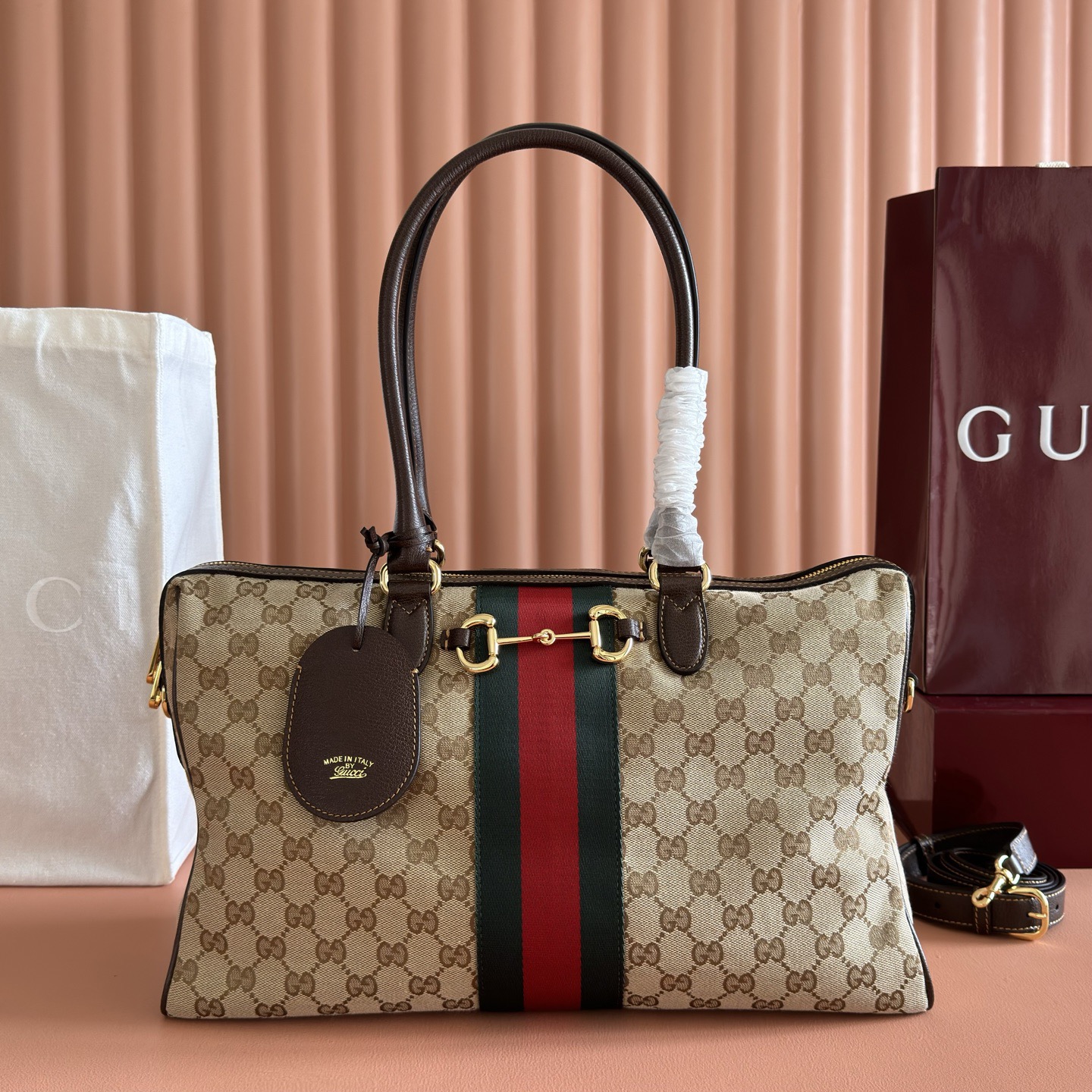 💋💋💋2026春夏系列全新上市。Gucci Borsetto系列名称巧妙融合意大利语“borsa”（手袋）和“morsetto”（马衔扣）二词。 这款手袋甄选柔软牛皮革打造，源自典藏的钻石菱格纹图案演绎全新衬里。 黑色软皮 金色调配件 黑色帆布衬里，饰钻石菱格纹图案 Horsebit、Web 和牛皮革标签，带有“Made in Italy Gucci”标志 内部：1个拉链口袋 手柄高：23厘米 可拆卸和可调节的牛皮革肩带，高：46 - 49厘米；长度：101 - 109厘米 双拉链开合 型号：866734。 尺寸：38.5厘米（宽）x 22.5厘米（高）x 13厘米（深） 重量：约0.9千克 颜色：啡色全皮。 意大利创作