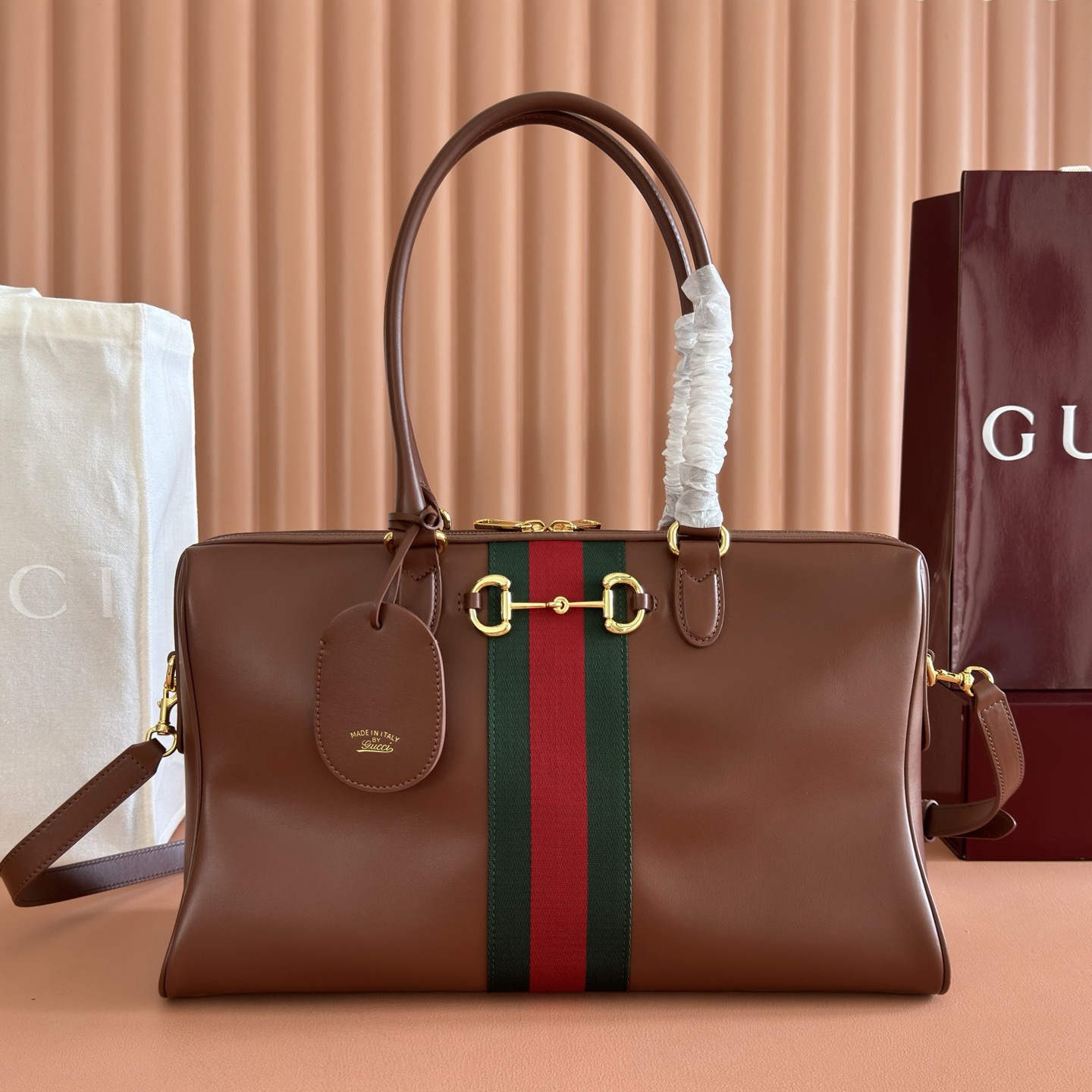 💋💋💋2026春夏系列全新上市。Gucci Borsetto系列名称巧妙融合意大利语“borsa”（手袋）和“morsetto”（马衔扣）二词。 这款手袋甄选柔软牛皮革打造，源自典藏的钻石菱格纹图案演绎全新衬里。 黑色软皮 金色调配件 黑色帆布衬里，饰钻石菱格纹图案 Horsebit、Web 和牛皮革标签，带有“Made in Italy Gucci”标志 内部：1个拉链口袋 手柄高：23厘米 可拆卸和可调节的牛皮革肩带，高：46 - 49厘米；长度：101 - 109厘米 双拉链开合 型号：866734。 尺寸：38.5厘米（宽）x 22.5厘米（高）x 13厘米（深） 重量：约0.9千克 颜色：棕色全皮。 意大利创作