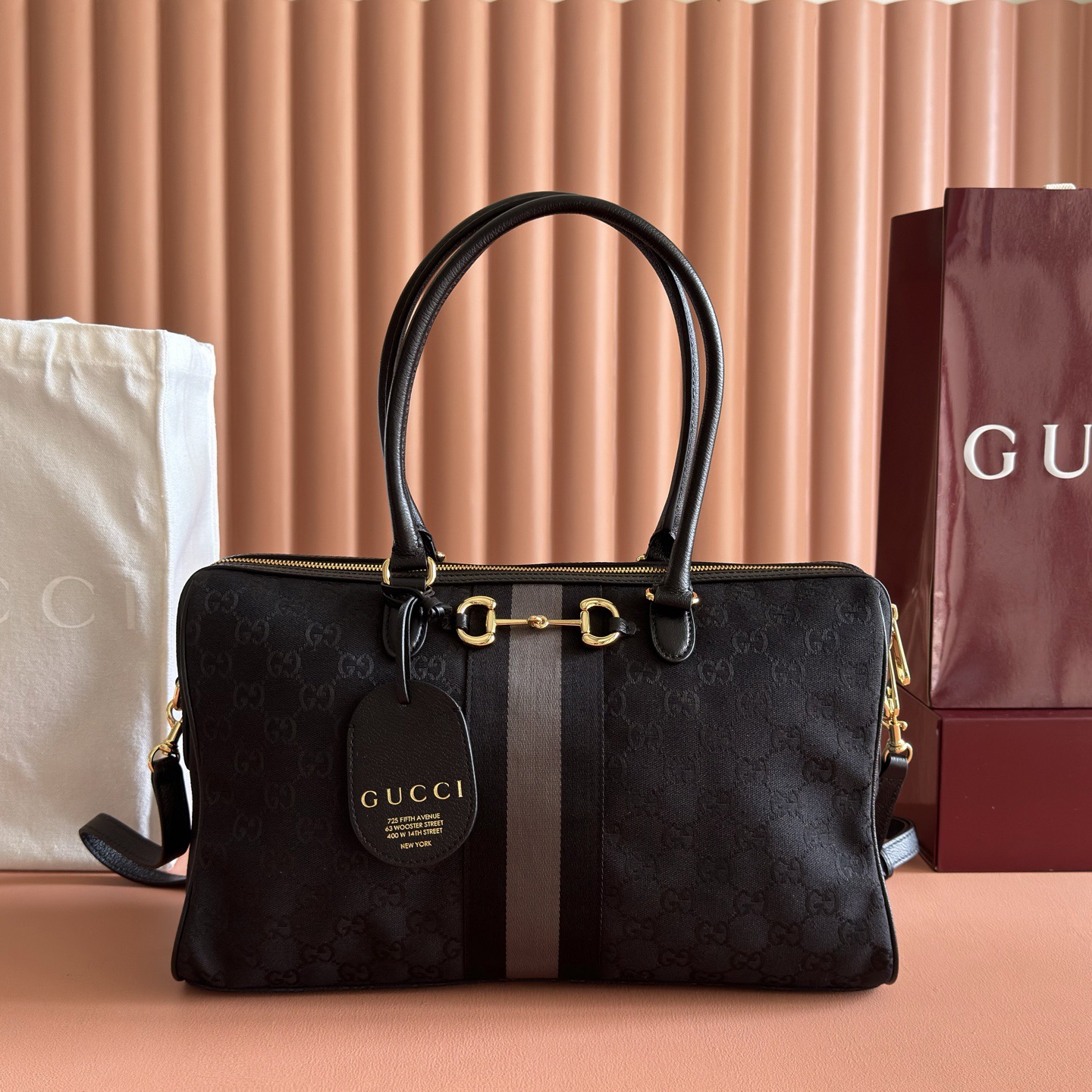💋💋💋2026春夏系列全新上市。Gucci Borsetto系列名称巧妙融合意大利语“borsa”（手袋）和“morsetto”（马衔扣）二词。 这款手袋甄选柔软牛皮革打造，源自典藏的钻石菱格纹图案演绎全新衬里。 黑色帆布 金色调配件 黑色帆布衬里，饰钻石菱格纹图案 Horsebit、Web 和牛皮革标签，带有“Made in Italy Gucci”标志 内部：1个拉链口袋 手柄高：23厘米 可拆卸和可调节的牛皮革肩带，高：46 - 49厘米；长度：101 - 109厘米 双拉链开合 型号：866734。 尺寸：38.5厘米（宽）x 22.5厘米（高）x 13厘米（深） 重量：约0.9千克 颜色：黑色帆布。 意大利创作