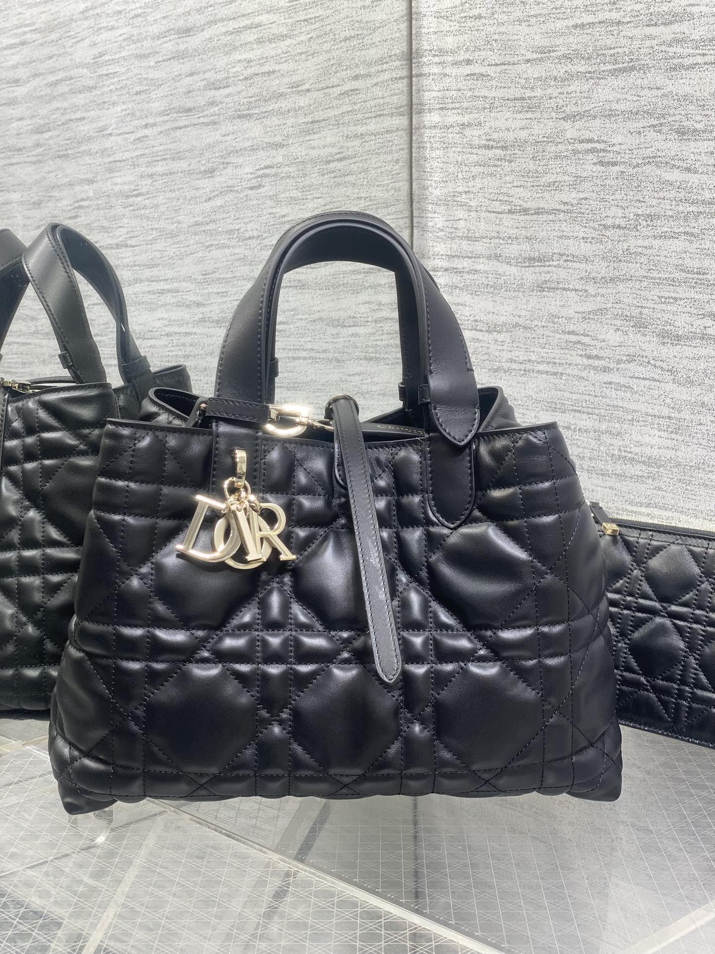 黑色中号现货‼️ Dior迪奥特级原单配全套原版包装 全新升级版本，内里牛皮羊纹 带着 Toujours 去旅行，超大菱格的设计，搭配经典的字母配饰，摩登时尚感十足，包身结构十分柔软，小牛皮材质高级感满满，别具一格的扣饰扣合时侧面可折叠，容量非常nice，还贴心的配有一枚内袋，方便收納小物品哦 size:28.5*19*21cm